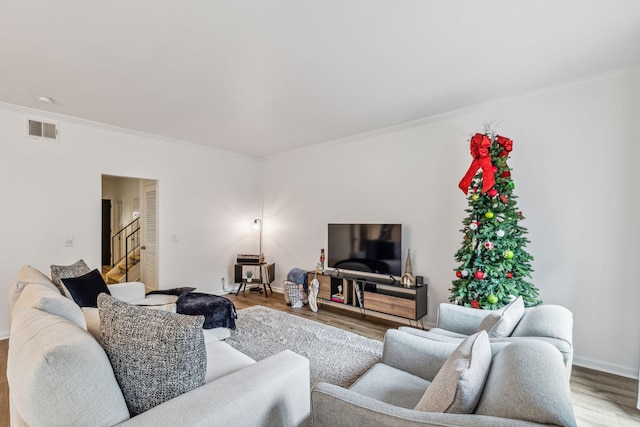 living room with hardwood / wood-style flooring and crown molding