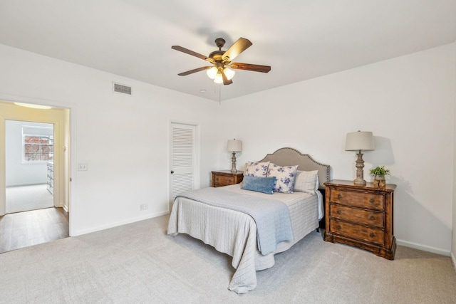 bedroom featuring ceiling fan, light colored carpet, and a closet