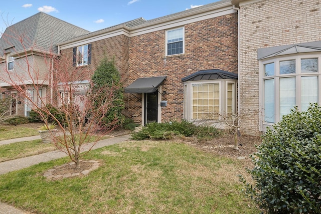 view of front of home featuring brick siding and a front yard