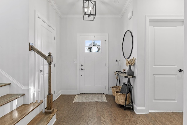 foyer with a chandelier, dark hardwood / wood-style flooring, and crown molding