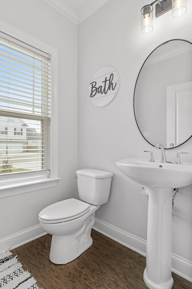 bathroom featuring toilet, wood-type flooring, and ornamental molding