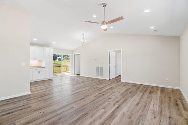 unfurnished living room with ceiling fan with notable chandelier, light hardwood / wood-style flooring, and vaulted ceiling