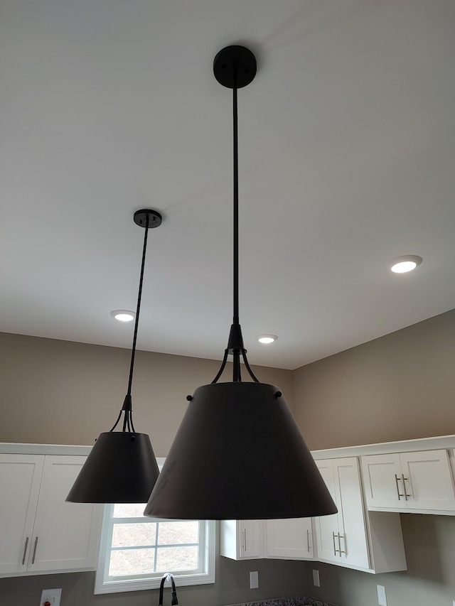 interior details with ventilation hood, decorative light fixtures, and white cabinetry