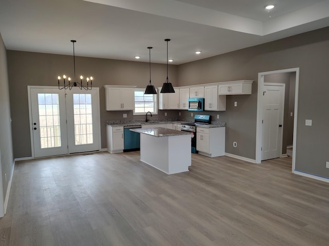 kitchen with appliances with stainless steel finishes, a center island, white cabinetry, and a wealth of natural light