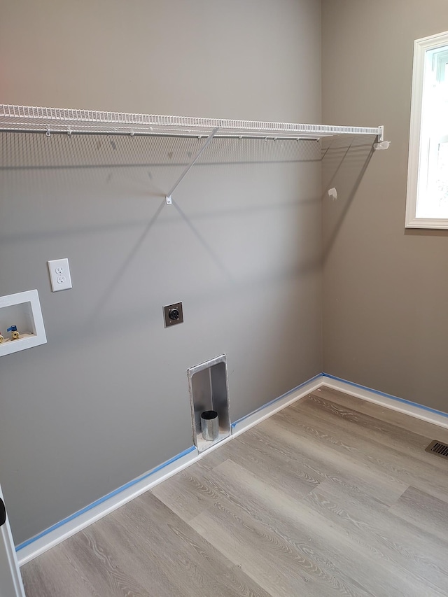 clothes washing area with hookup for an electric dryer, hardwood / wood-style floors, and washer hookup