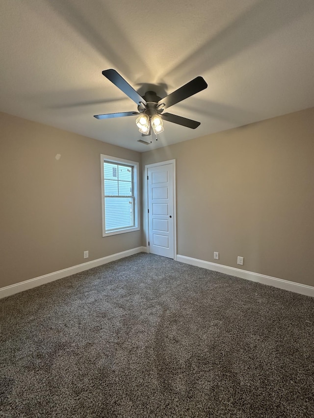 unfurnished room featuring ceiling fan, baseboards, and dark colored carpet