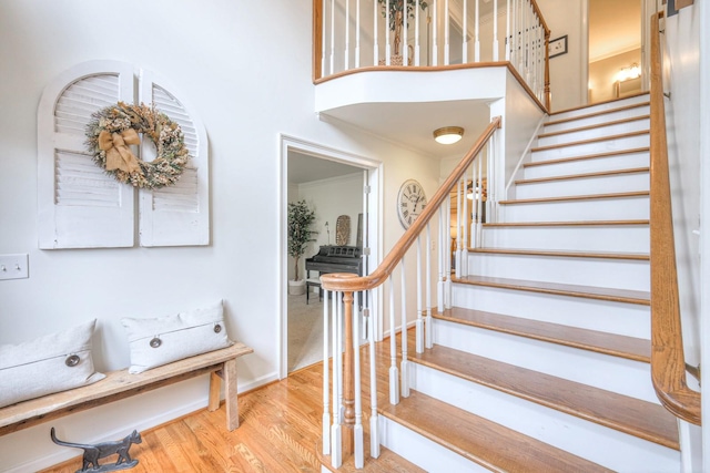 stairs featuring hardwood / wood-style floors and a high ceiling