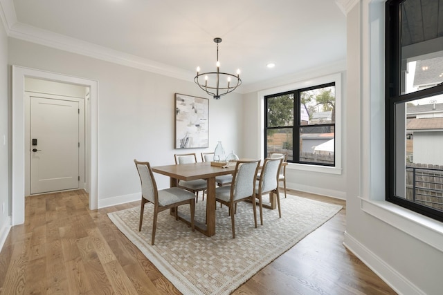 dining space featuring crown molding, a chandelier, and light wood-type flooring