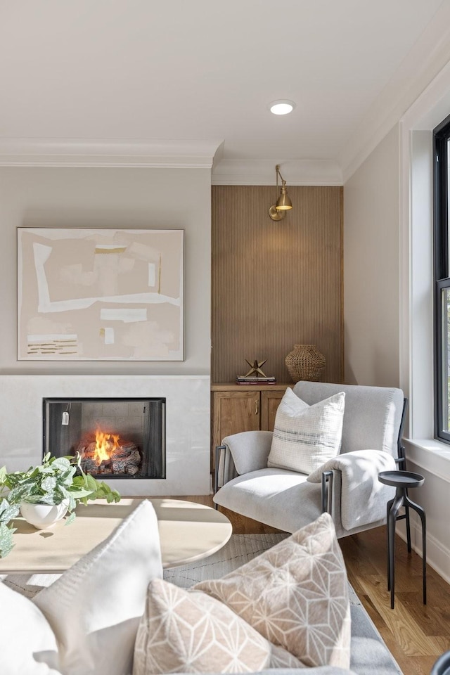 living area featuring crown molding and wood-type flooring