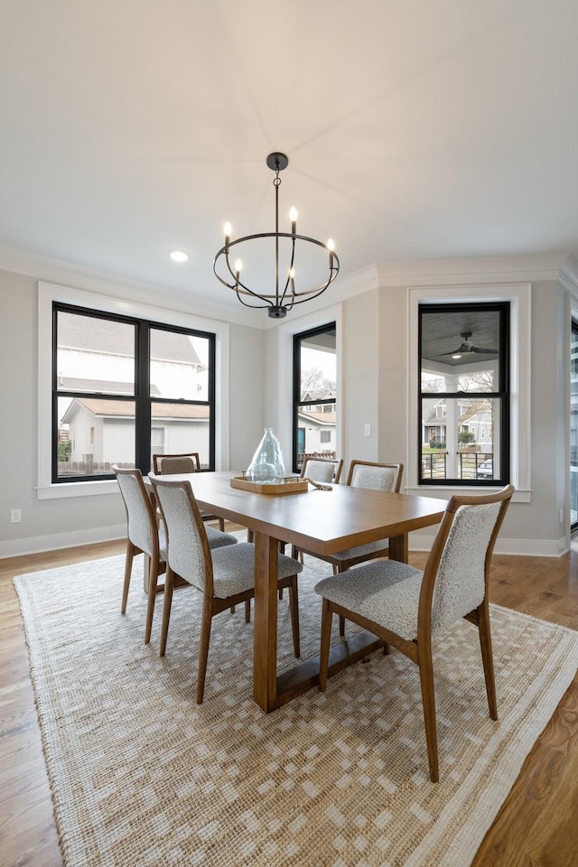 dining space with crown molding, a chandelier, and light hardwood / wood-style floors