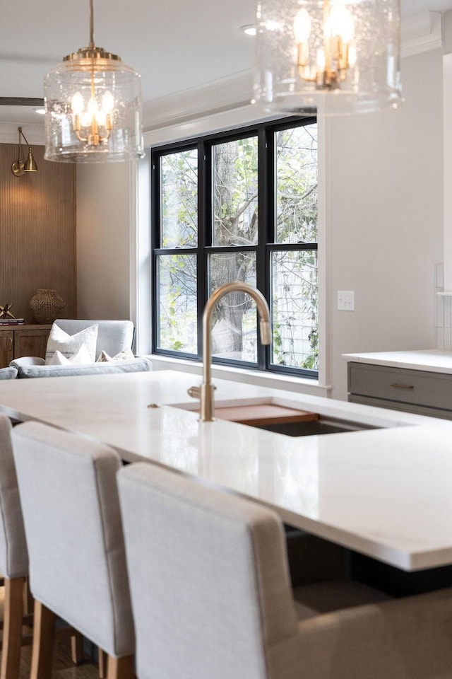 dining area featuring ornamental molding, sink, and a chandelier