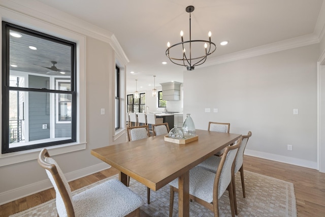 dining space featuring wood-type flooring, a notable chandelier, and crown molding