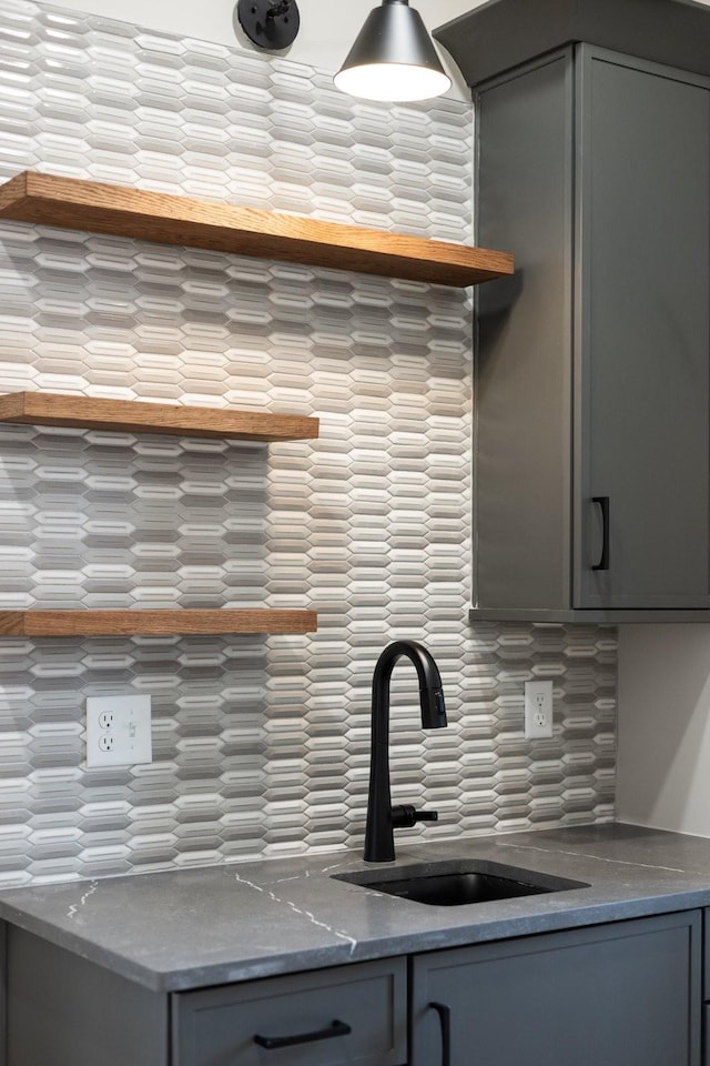 kitchen with tasteful backsplash, gray cabinets, and sink