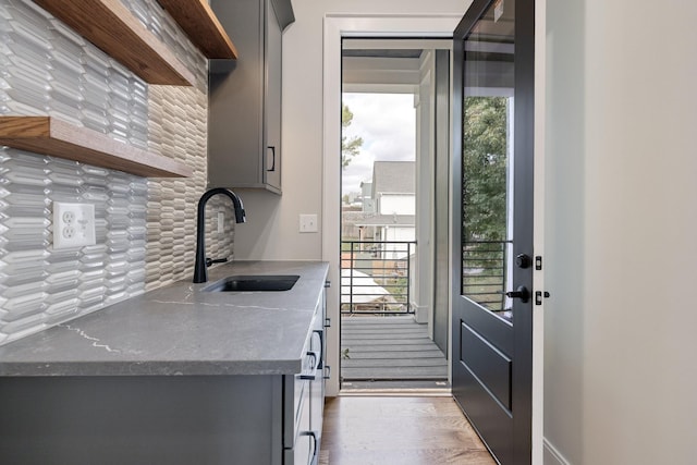 kitchen featuring gray cabinetry, a healthy amount of sunlight, sink, and backsplash