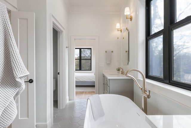 bathroom featuring crown molding, tile patterned floors, a bathtub, and vanity