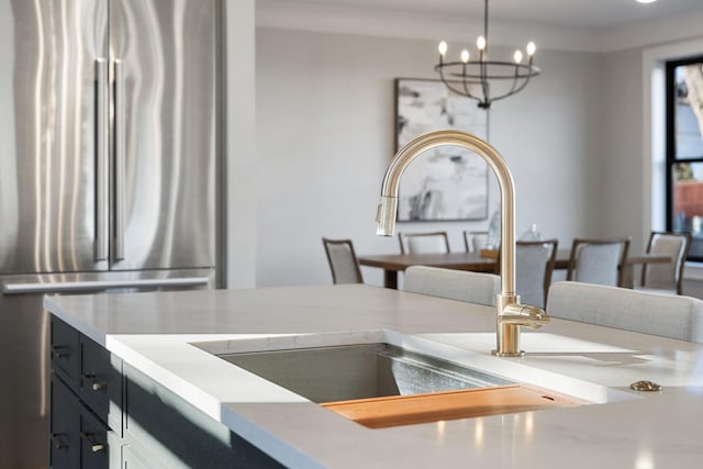 interior space featuring sink, stainless steel fridge, and a chandelier