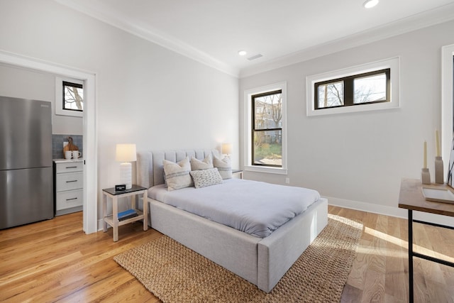 bedroom featuring stainless steel refrigerator, crown molding, and light hardwood / wood-style floors