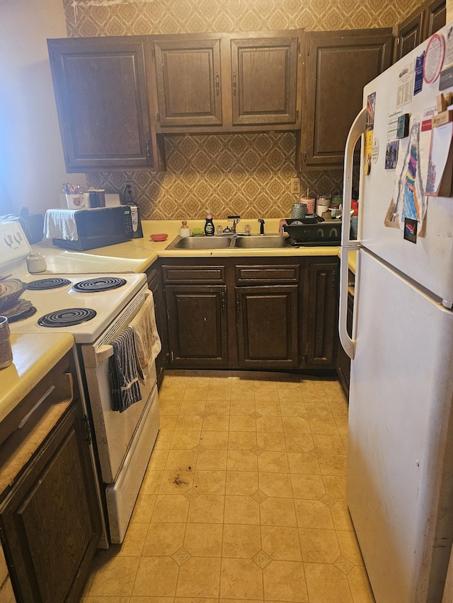 kitchen featuring decorative backsplash, white appliances, dark brown cabinetry, and sink