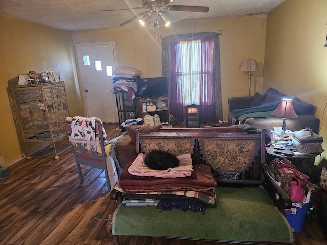 living room with ceiling fan, hardwood / wood-style floors, and a textured ceiling