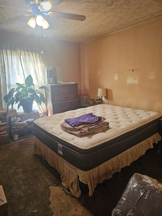 carpeted bedroom featuring ceiling fan and a textured ceiling