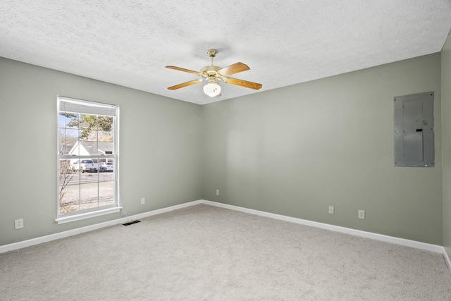 unfurnished room featuring a textured ceiling, carpet floors, electric panel, and ceiling fan