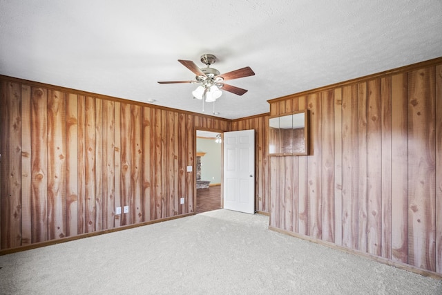 empty room featuring ceiling fan, crown molding, and light colored carpet