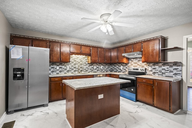 kitchen with dark brown cabinetry, stainless steel appliances, ceiling fan, sink, and a kitchen island