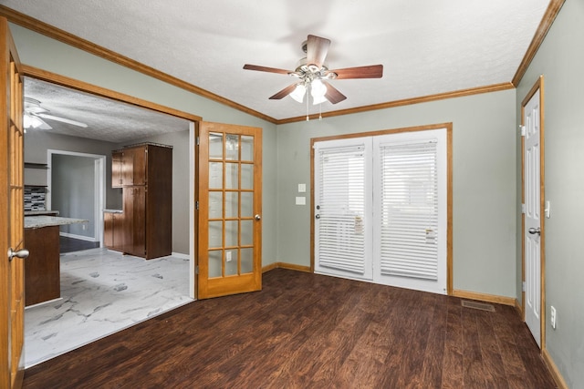 empty room featuring french doors, a textured ceiling, ornamental molding, and hardwood / wood-style floors