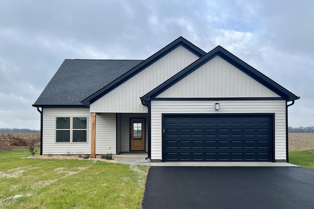 modern farmhouse style home with a front yard and a garage