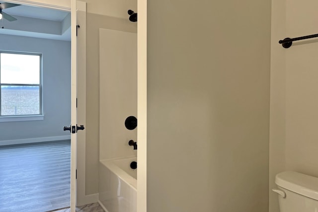 bathroom featuring wood-type flooring, bathtub / shower combination, and toilet