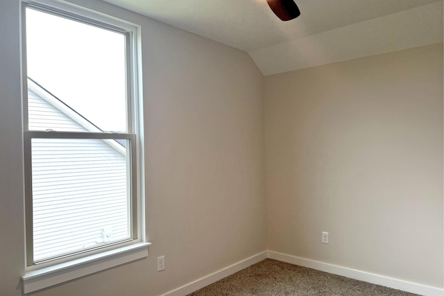 spare room with carpet floors and vaulted ceiling