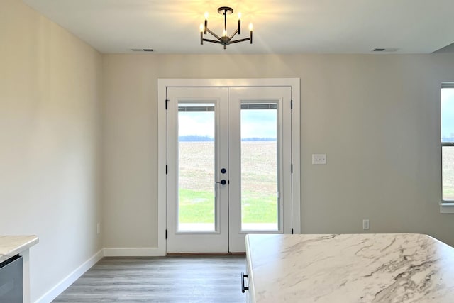 entryway with french doors, hardwood / wood-style flooring, and an inviting chandelier