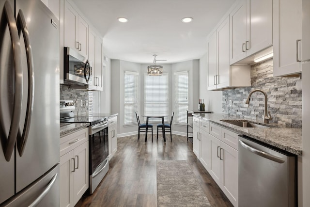 kitchen featuring appliances with stainless steel finishes, white cabinetry, dark wood-type flooring, and sink