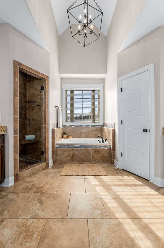 bathroom with high vaulted ceiling, plus walk in shower, and an inviting chandelier