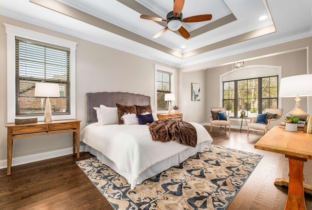 bedroom with ceiling fan, crown molding, dark wood-type flooring, and a tray ceiling