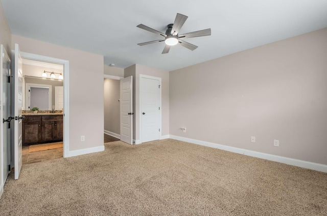 unfurnished bedroom with carpet, ensuite bathroom, ceiling fan, and a closet