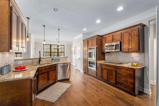 kitchen featuring dark wood-type flooring, crown molding, sink, appliances with stainless steel finishes, and decorative light fixtures