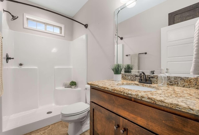 bathroom featuring tile patterned flooring, vanity, toilet, and walk in shower