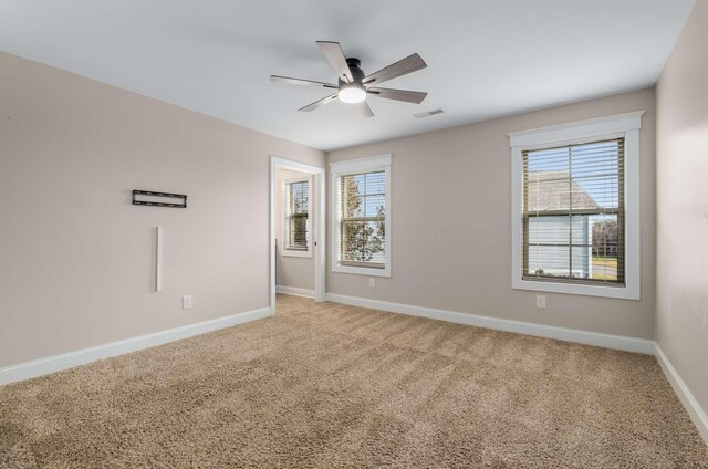 empty room featuring carpet flooring, plenty of natural light, and ceiling fan