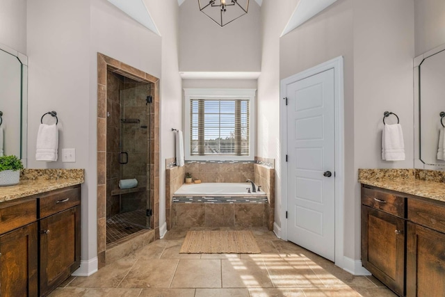 bathroom with vanity, tile patterned flooring, a towering ceiling, independent shower and bath, and a chandelier