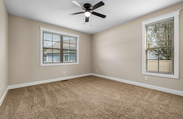 carpeted spare room with ceiling fan