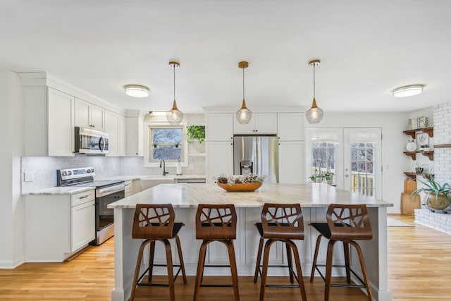 kitchen with stainless steel appliances, a kitchen island, and a wealth of natural light