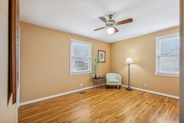 unfurnished room with light wood-type flooring, a wealth of natural light, and ceiling fan