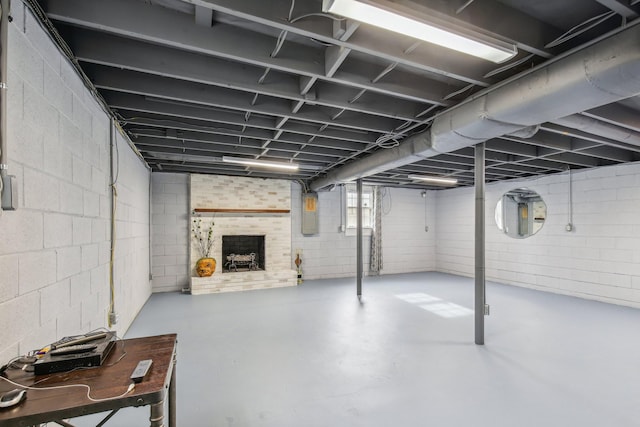 basement with a fireplace and electric panel