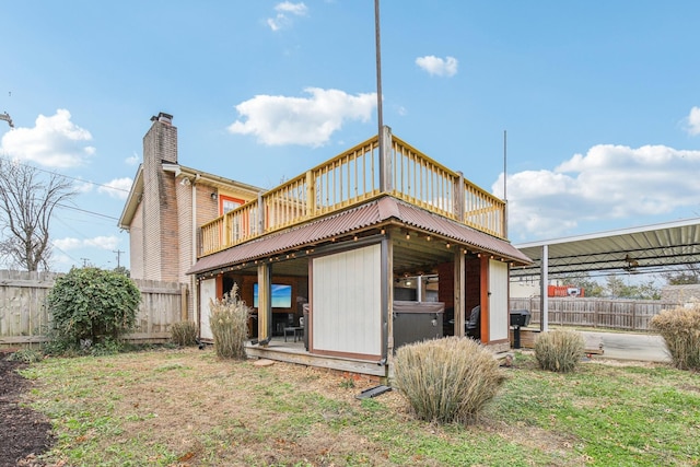 rear view of property with a lawn, a wooden deck, and an outdoor structure