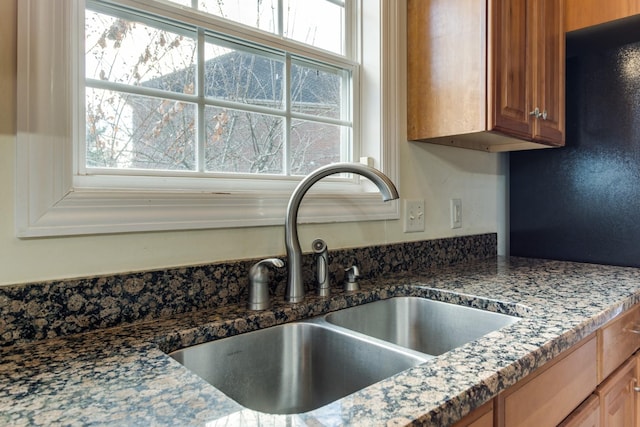 room details featuring dark stone countertops and sink