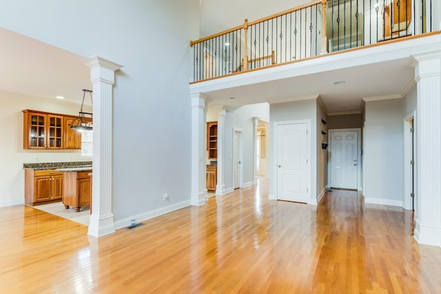 unfurnished living room with light hardwood / wood-style floors and ornamental molding