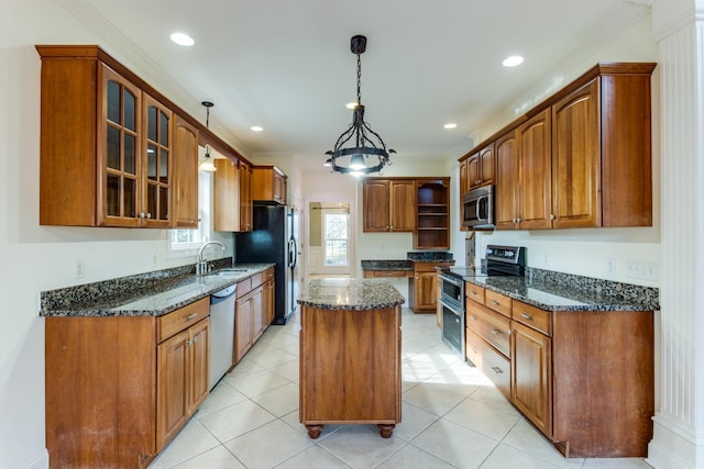 kitchen with appliances with stainless steel finishes, a center island, pendant lighting, and dark stone countertops