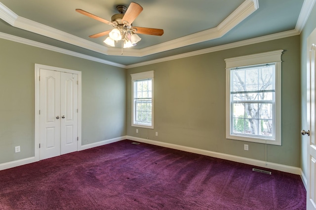 carpeted empty room featuring a tray ceiling, ceiling fan, and ornamental molding