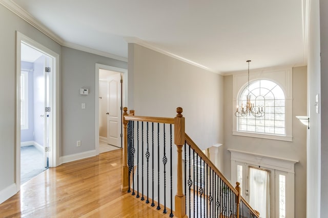 interior space featuring a notable chandelier, ornamental molding, and light hardwood / wood-style flooring